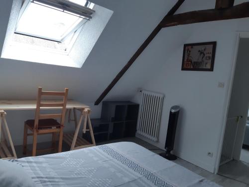 a bedroom with a bed and a window and a desk at Guingamp, maison de ville in Guingamp