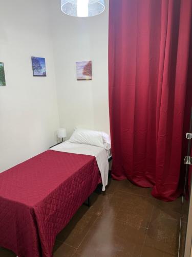 a bedroom with two beds and red curtains at Sc Residence Parma in Parma