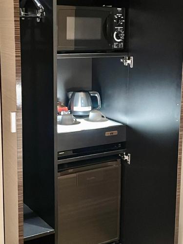 a kitchen with a sink and a microwave at Hotel BIX チェックイン23時 変更不可 in Tokyo