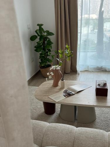 a living room with a coffee table and potted plants at Desert Home Mayan Yas Island in Abu Dhabi