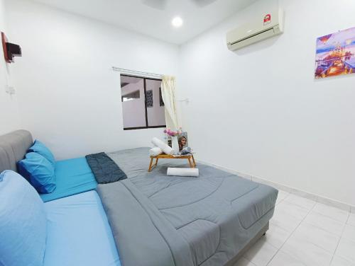 a living room with a blue couch and a chair at Bukit Beruang 366D Family Home - Private Pool in Melaka
