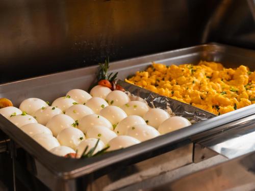 a tray filled with eggs and other food items at Mauad Hotel Boutique in Santo Domingo