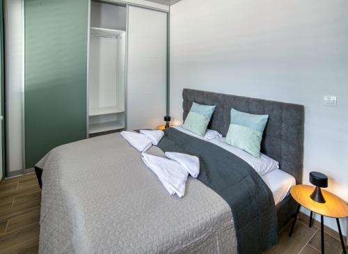 a bedroom with a large bed with blue pillows at DUO Residences in Dunajská Streda