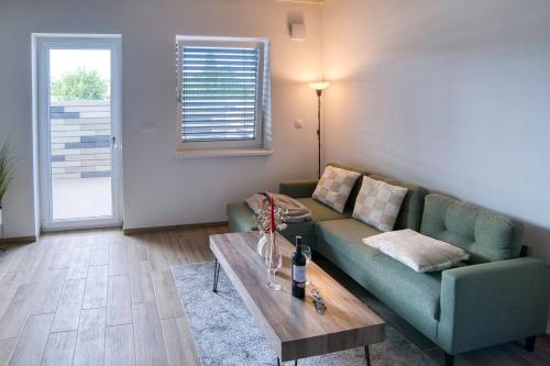 a living room with a green couch and a table at DUO Residences in Dunajská Streda
