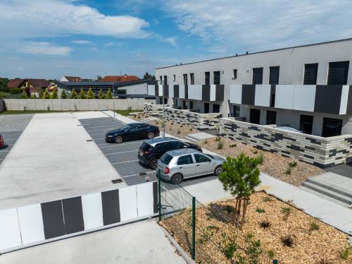two cars parked in a parking lot in front of a building at DUO Residences in Dunajská Streda