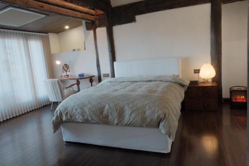 a bedroom with a large bed and a wooden floor at Dali Healing Yard 喜洲禾隐星登 in Dali