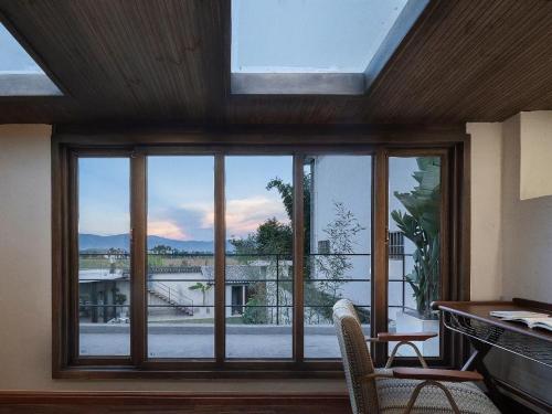 a room with a large window with a view at Dali Healing Yard 喜洲禾隐星登 in Dali