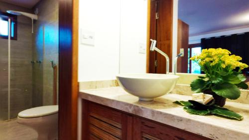 a bathroom with a sink and a bowl on a counter at Araticum Praia Hotel in Santo André