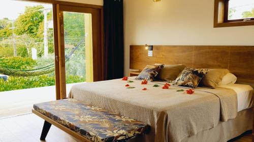 a bedroom with a bed with flowers on it at Araticum Praia Hotel in Santo André