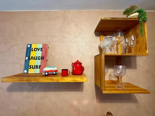 two wooden shelves with wine glasses and a book at Loft Dreamtime - a 80 metros do Rio das Almas! in Pirenópolis