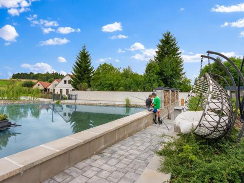 two people standing next to a swimming pool at Holiday Home Ayurvedic Palace by Interhome 