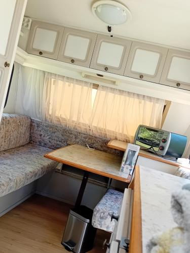 a small table in a tiny house with a desk at Camping Voi-la-la-vie in Saint-Christophe-en-Boucherie