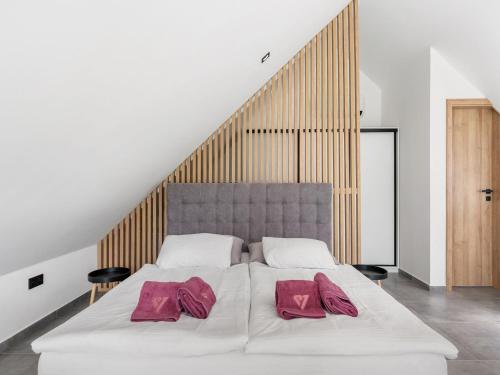 a white bed with two pink pillows on it at Holiday Home Romance & Relax Villa by Interhome 