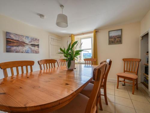 Un comedor con mesa y sillas de madera. en Holiday Home The Manor House by Interhome, en Balnain