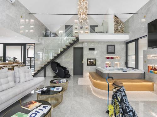 a living room with a staircase and a couch at Holiday Home Luxury Retreat Resort by Interhome 