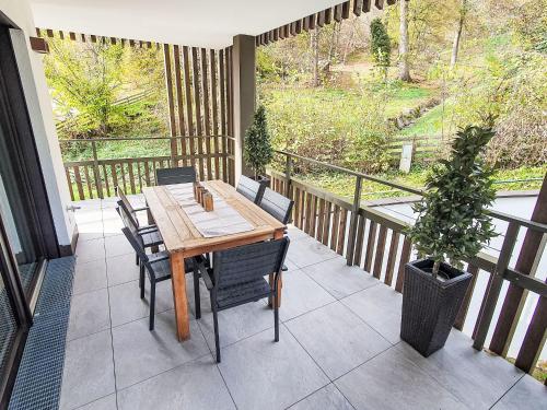a porch with a wooden table and chairs on a balcony at Apartment Edelbach Deluxe 1 by Interhome in Sattendorf