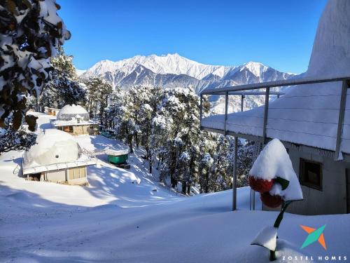 a snow covered hill with mountains in the background at Zostel Homes Billing - Bir in Biling