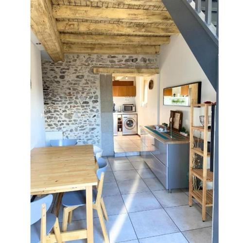 a kitchen with a wooden table and a kitchen with a stove at La table ronde in Vienne