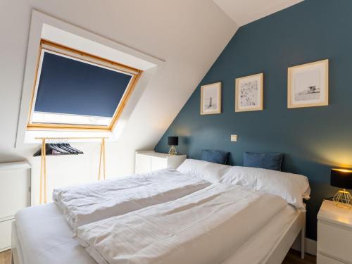 una camera con un letto bianco e una parete blu di Apartment Green Garden-16 by Interhome a De Haan
