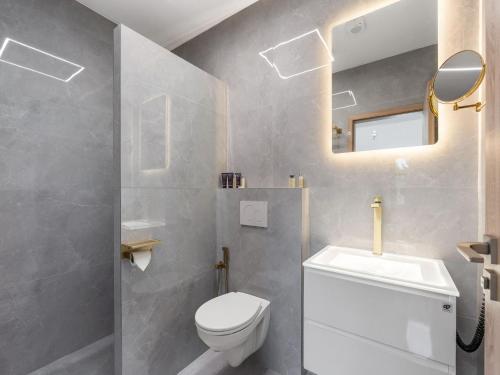 a bathroom with a toilet and a sink and a mirror at Holiday Home Party & Friends Villa by Interhome 