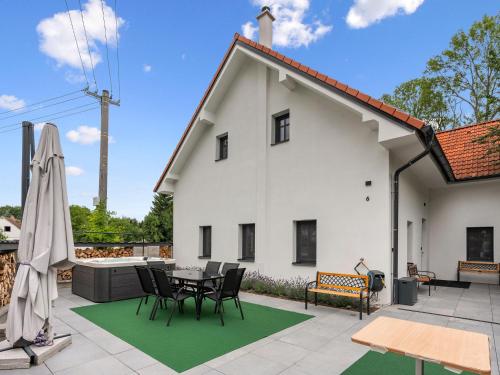 a white house with a patio with a table and chairs at Holiday Home Party & Friends Villa by Interhome 