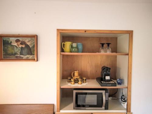 a shelf with a microwave in a room at Apartment Alpenfarm Poschhof by Interhome in Kaunerberg