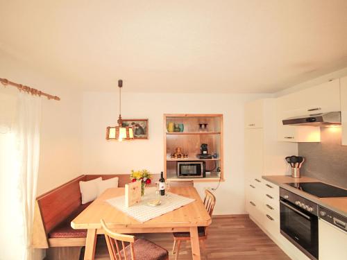 a small kitchen and dining room with a wooden table at Apartment Alpenfarm Poschhof by Interhome in Kaunerberg
