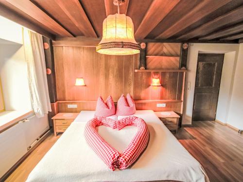 a room with a bed with two pillows in the shape of a heart at Apartment Alpenfarm Poschhof by Interhome in Kaunerberg