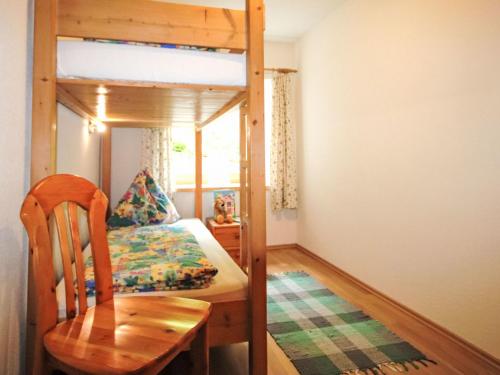 a bedroom with a bunk bed and a table and a chair at Apartment Alpenfarm Poschhof by Interhome in Kaunerberg
