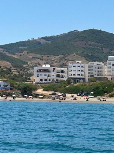 a group of buildings on a beach with cars parked at Oumaira Residence Azla-Tetouan in Azla