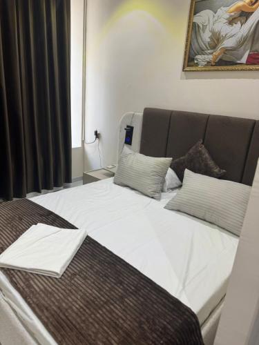 a bedroom with a large bed with white sheets at Eligant Boutique Hotel Baku in Baku