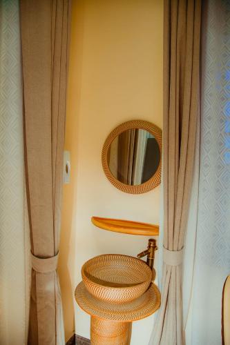 a bathroom with two curtains and a mirror at Ais apartments in Zanzibar City