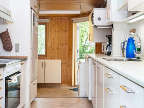 a kitchen with white appliances and wooden walls at 5 person holiday home in Odder-By Traum in Odder
