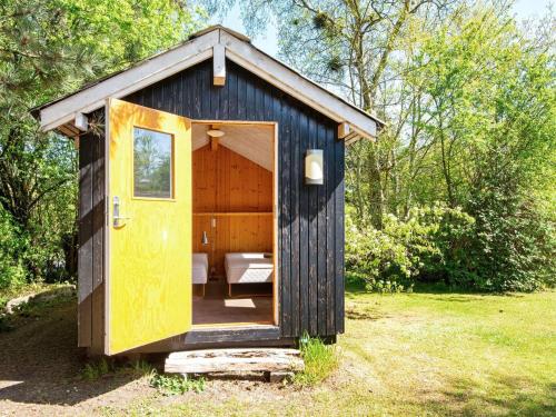 a small shed with a yellow door in a yard at 5 person holiday home in Odder-By Traum in Odder