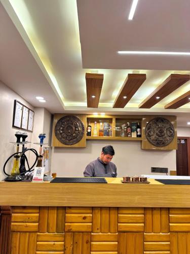 a man standing behind a counter in a kitchen at Hotel Caravan in Muktināth