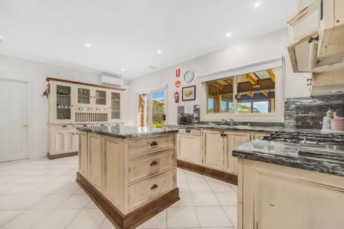 a large kitchen with wooden cabinets and a counter top at The Manor in Blue Mountains in Wentworth Falls