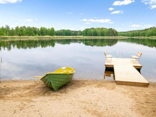 un bateau sur la rive d'un lac avec un quai dans l'établissement Holiday Home Käpälämäki by Interhome, à Putkijärvi