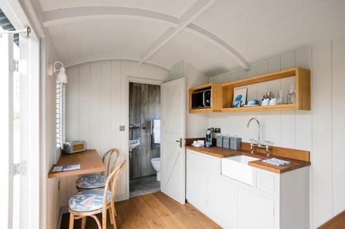 a kitchen with a sink and a toilet in a room at Shepherds Huts at The Cornish Arms in Saint Merryn