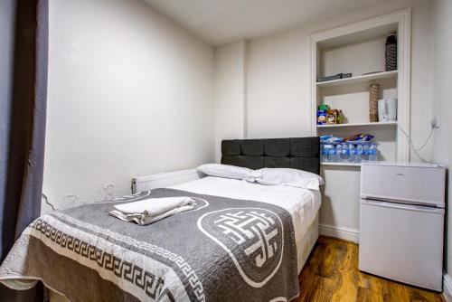 a small bedroom with a bed with a blanket on it at Willmore Hotel in London