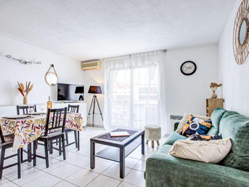 a living room with a green couch and a table at Apartment Atrium by Interhome in Caves