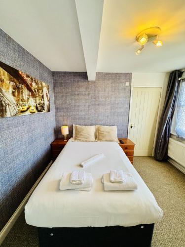 a bedroom with a large bed with two towels on it at Carlton Court Hotel Eastbourne in Eastbourne