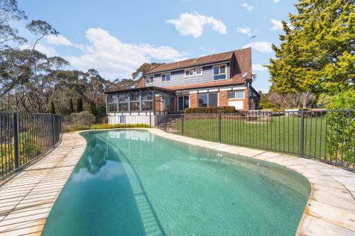 a swimming pool in front of a house at The Manor in Blue Mountains in Wentworth Falls