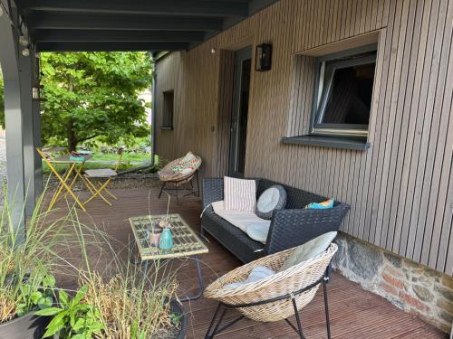 a patio with a couch and chairs on a porch at Apartment Hinterhov Nest by Interhome in Beeskow