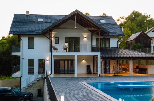 a house with a swimming pool in front of it at Dimar Retreat Villa in Moisei