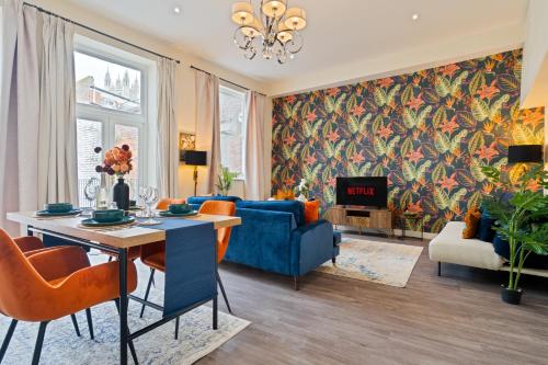 a living room with a blue couch and a table at Spacious Luxury 2 Bedroom City Centre Apartment with Terrace & High Ceiling in Canterbury