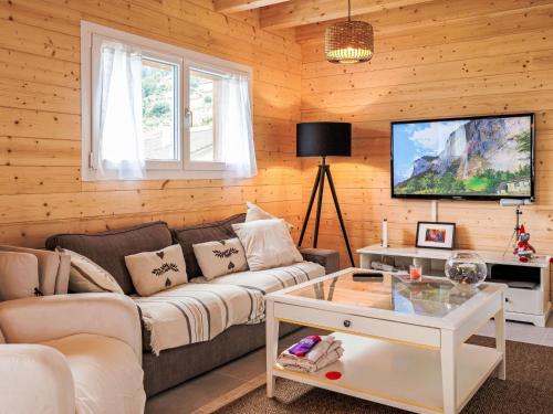 a living room with a couch and a tv at Chalet Oxygène by Interhome in Plan Fey
