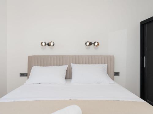 a bedroom with a white bed with two lights above it at Holiday Home Sime by Interhome in Maslenica