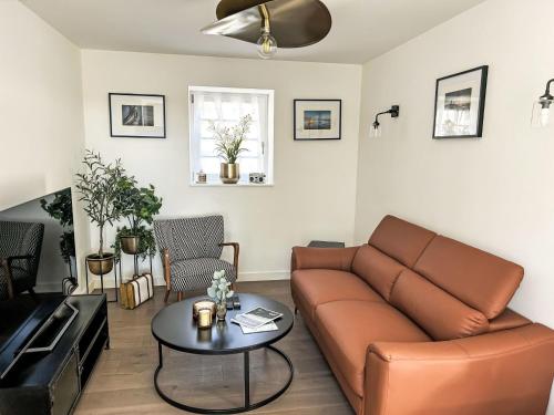 a living room with a couch and a table at Holiday Home Le petit Papeu by Interhome in Frehel