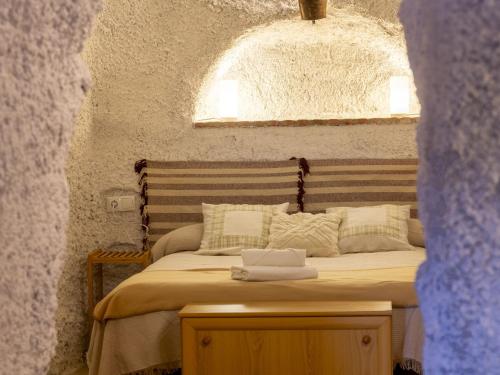 a bedroom with a large bed with a wooden table at Holiday Home Cueva Mariana Pineda by Interhome in Terque