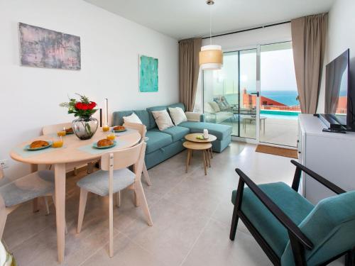 a living room with a blue couch and a table at Apartment Heaven Free Spa & Padel by Interhome in Torrox Costa